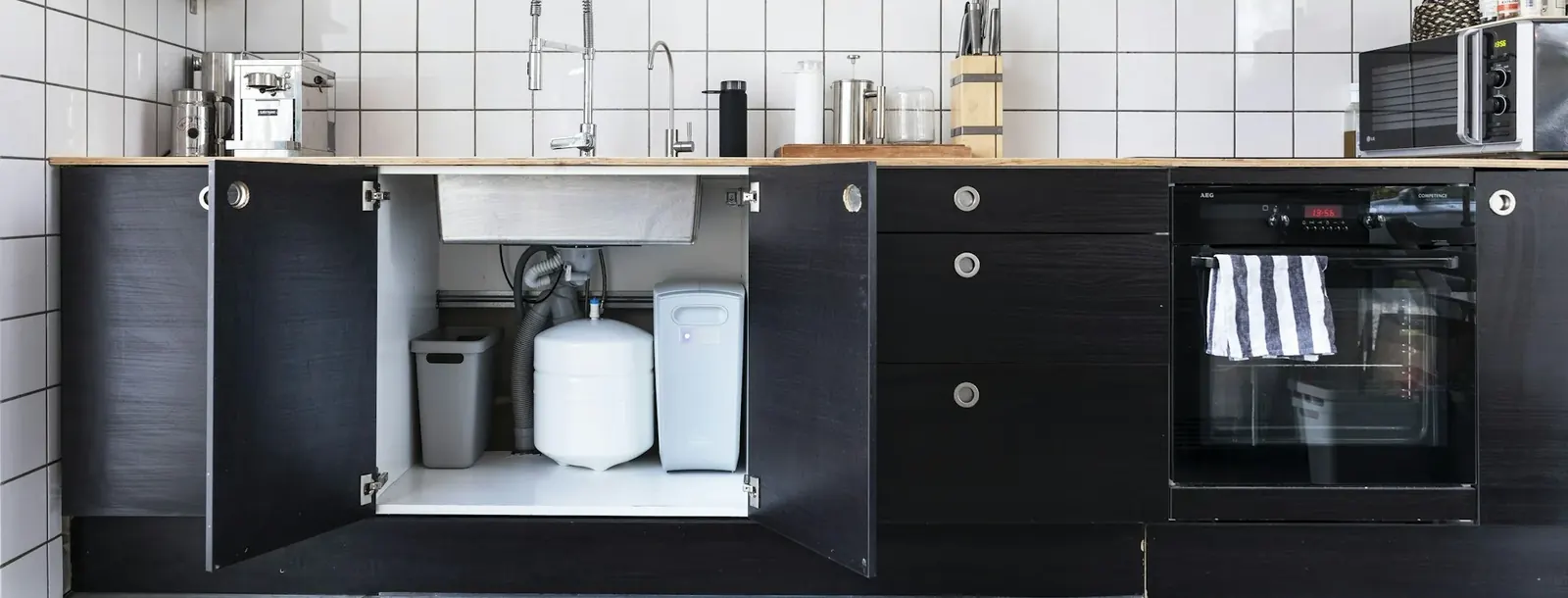 Kitchen cabinet with a compact water filtration unit installed