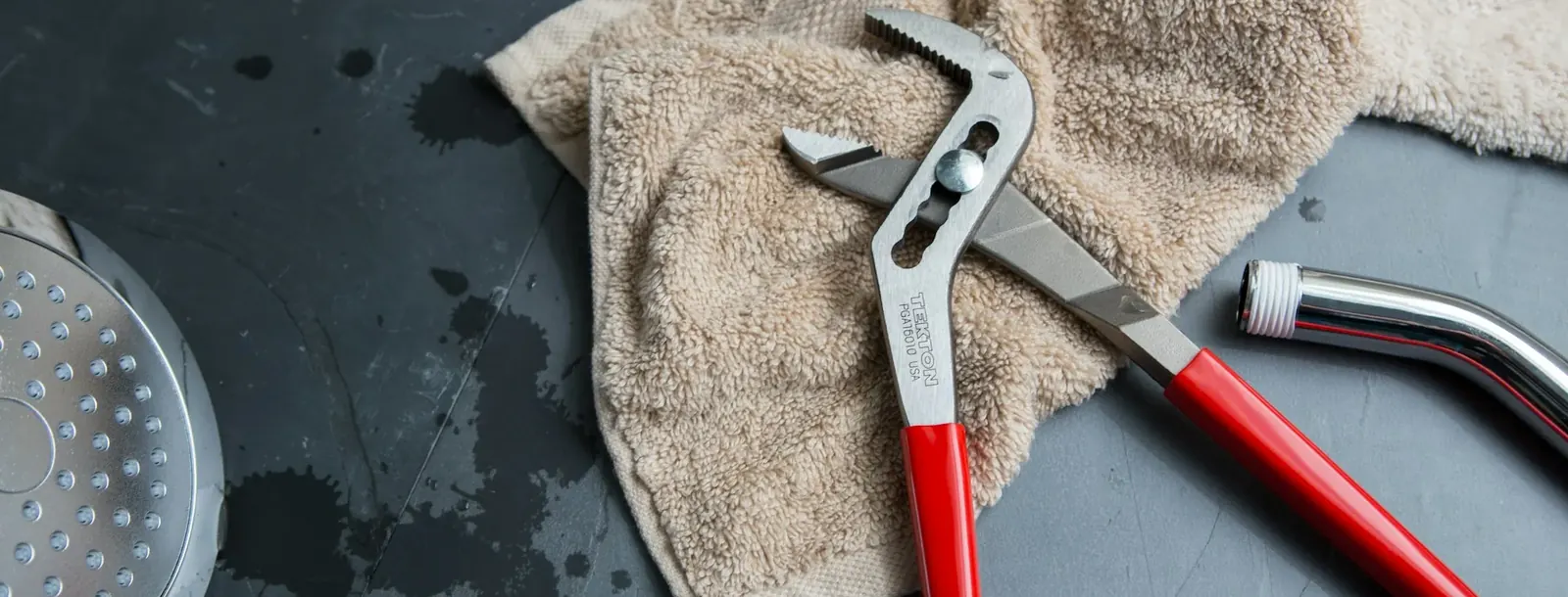 Pliers and a cloth beside plumbing parts