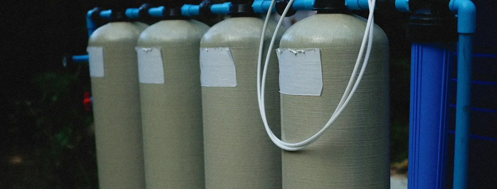 Pair of fiberglass softener tanks plumbed with blue pipe
