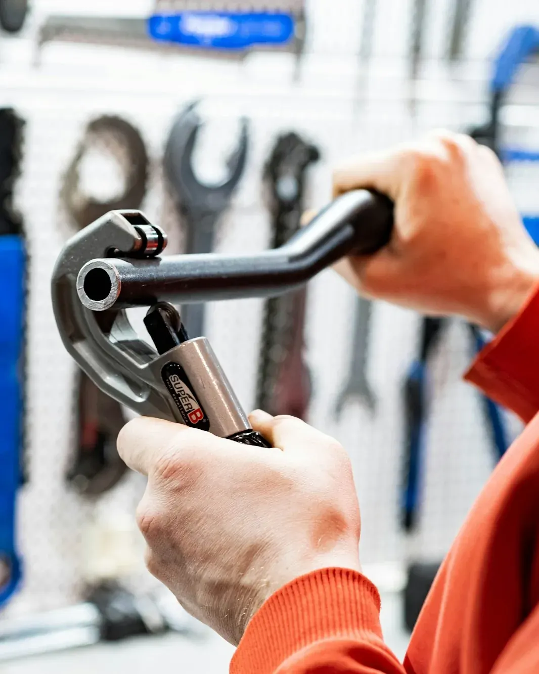 Technician choosing a wrench from a pegboard of tools